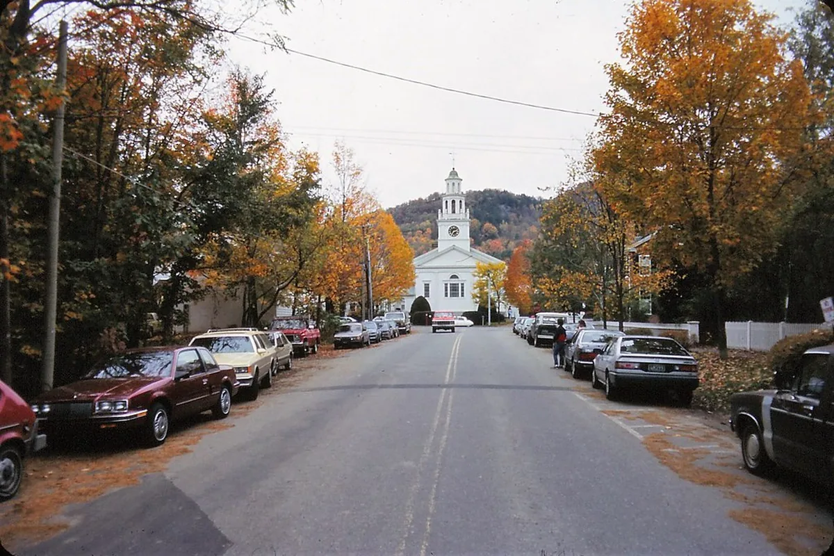 A church-lined street framed by autumn foliage in Woodstock, Vermont